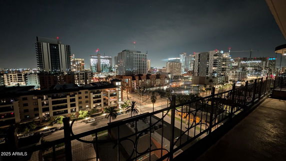 Night panoramic view of a cityscape with illuminated buildings.