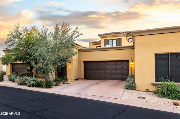 Front view of a house with a two-car garage and stucco exterior.