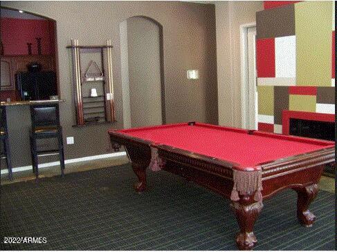 Room with a red pool table and modern decor.