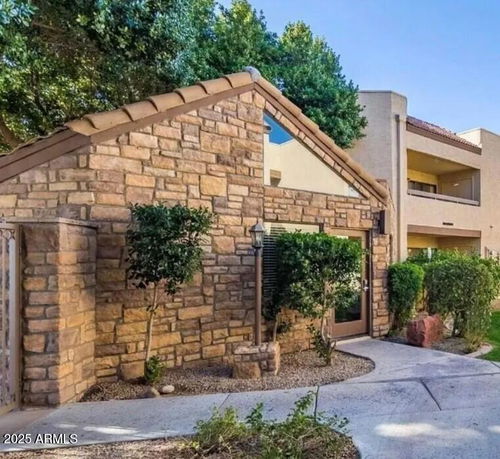 Front view of a building with stone exterior and a sloped roof.