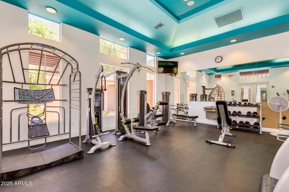 Indoor gym area with fitness equipment and mirrored walls.