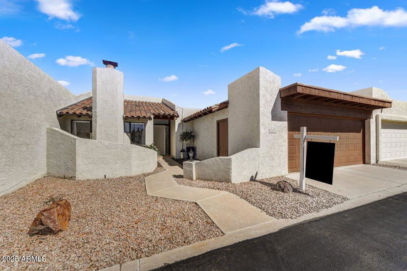 Front view of a house with a garage and distinctive design elements.