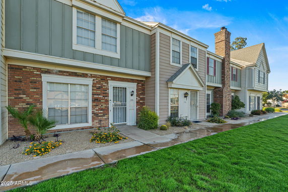 Front view of a two-story townhouse with brick and siding facade.