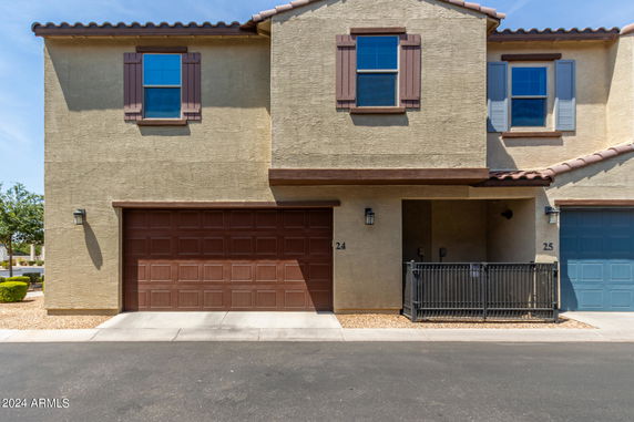 Front view of a two-story townhouse with a single brown garage door.