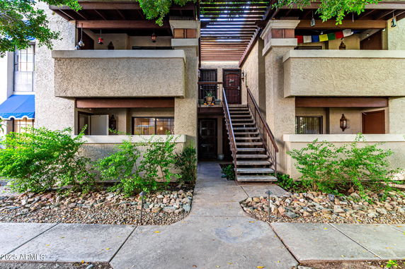 Front view of a multi-story apartment building with exterior staircase.