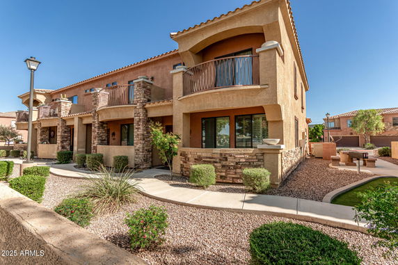 Front view of a two-story house with a stone accent exterior and balconies.