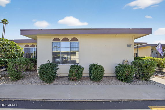 Front view of a single-story building with a flat roof and large window.