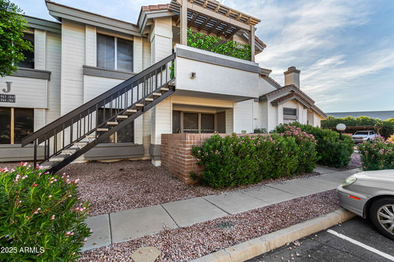Front view of a two-story residential building with an exterior staircase.