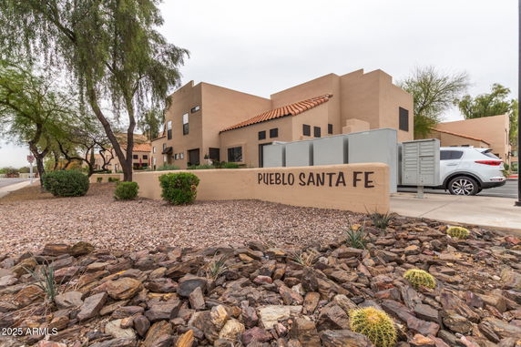 Front view of a building with flat roofs and a desert landscape setting.