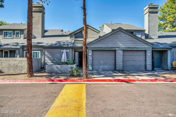 Front view of a house with two garages and chimneys.