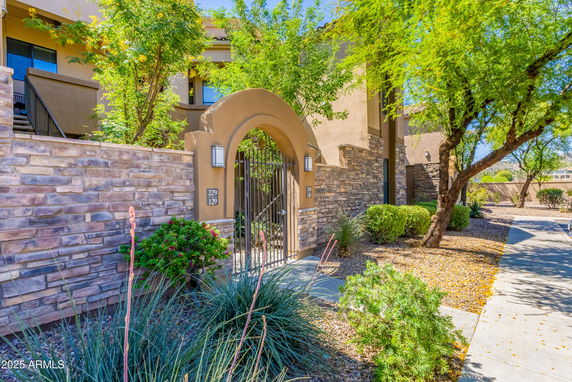Front view of a house with stone walls and an arched gate entrance.