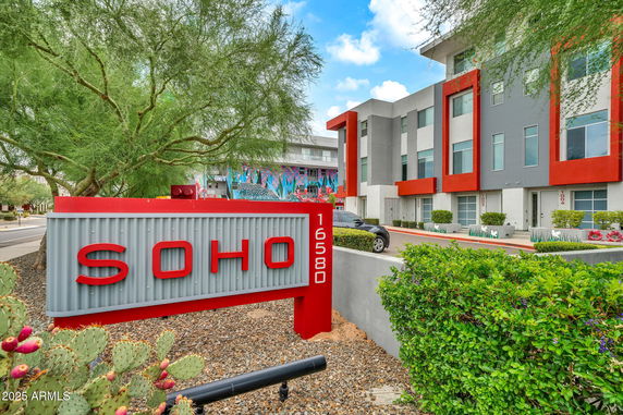 Front view of a modern multi-story apartment building with colorful accents.