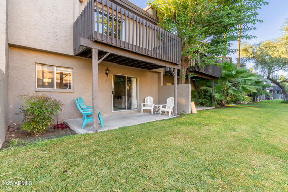 Front view of a building with a small patio and wooden balcony.