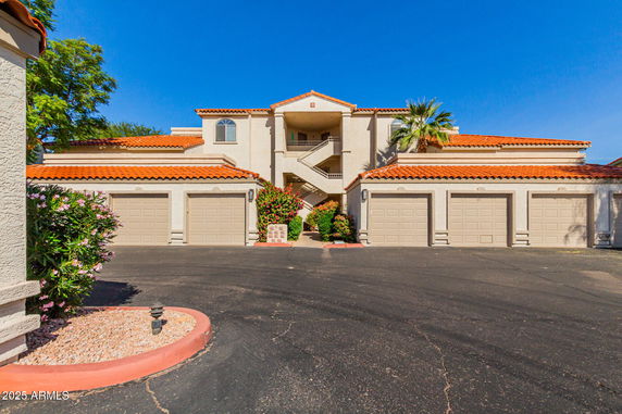 Front view of a multi-story building with garages and a central staircase.