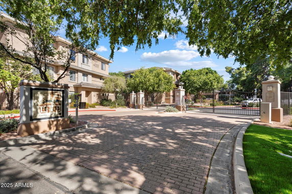 Front view of a multi-story residential building with gated entrance.