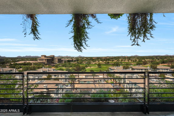 Panoramic view from a balcony overlooking a residential area and landscape.