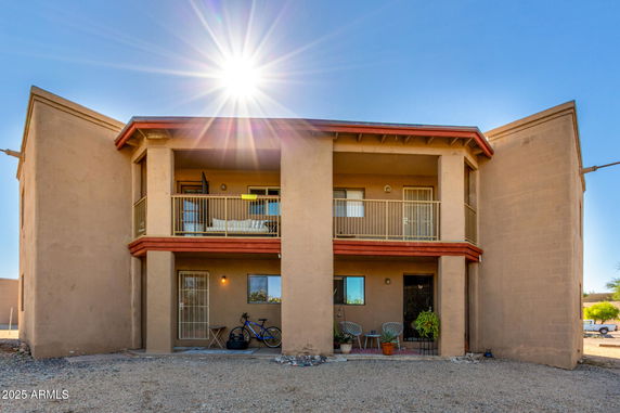 Front view of a two-story house with balconies and large columns.