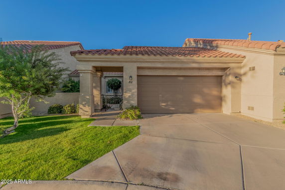 Front view of a house with a tan garage door and tiled roof.
