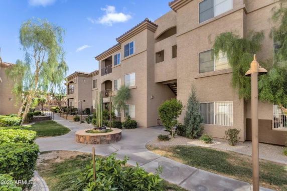 Front view of a multi-story apartment building with landscaped pathways.