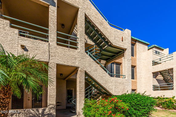 Front view of a multi-story residential building with external staircases.
