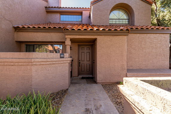 Front view of a house with a tiled roof and arched window.