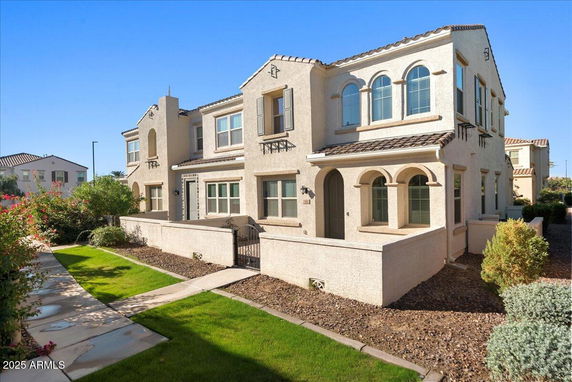 Front view of a two-story house with arched windows and a tiled roof.