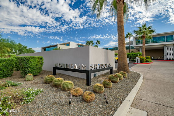 Front view of a modern building with large windows and a sign reading 'Mountain Shadows'.