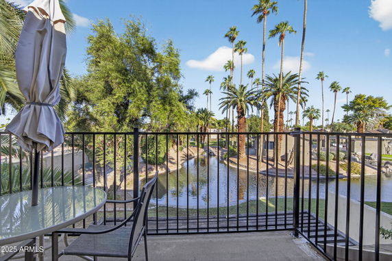 View of palm trees and a waterway from a balcony.