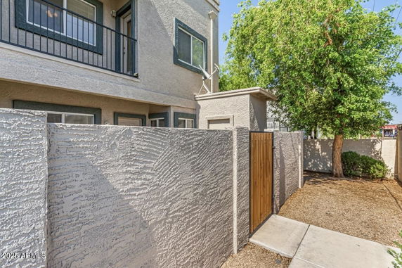 Elevation view of a two-story building with a balcony and textured exterior walls.