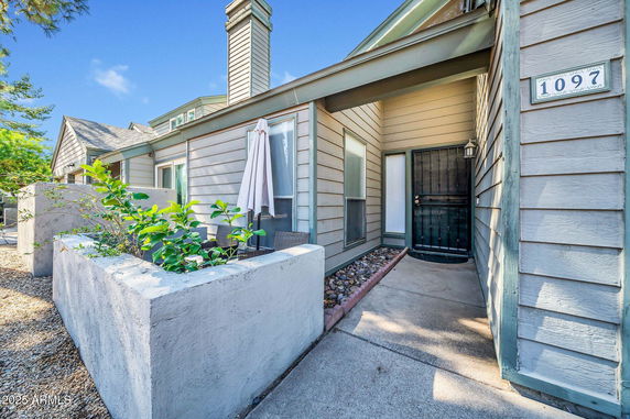 Front view of a single-story house with a chimney and a front porch.