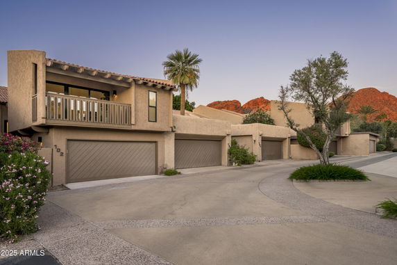 Front view of a house with a balcony and double garage.