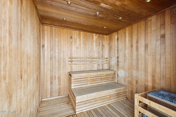 Wooden sauna room with benches and a heater.