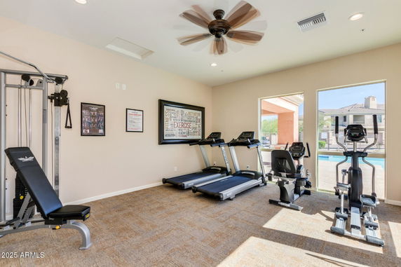 Interior view of a gym with exercise equipment including treadmills, a stationary bike, and a weight machine.