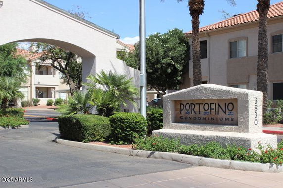 Front view of a multi-story condominium complex with an entrance sign.