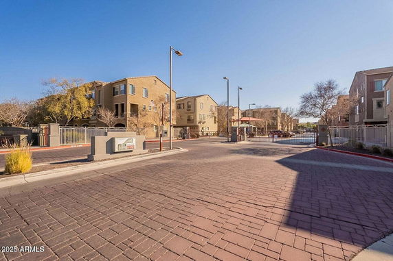Front view of a multi-story residential building with gated entrance.