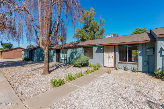 Front view of a single-story house with a long, low roofline and multiple windows.