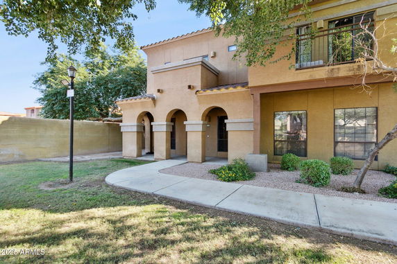 Front view of a house with arched entrances and a small garden.