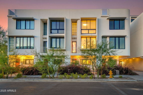 Front view of a modern multi-story building with large windows.