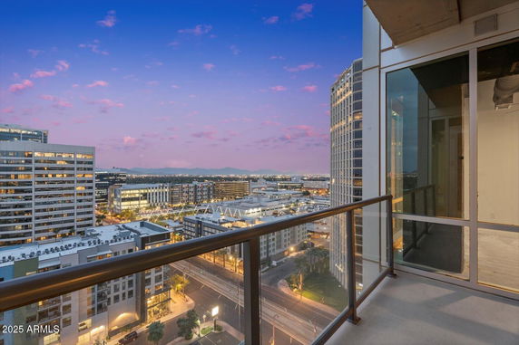 Panoramic view from a high-rise balcony overlooking surrounding buildings at dusk.