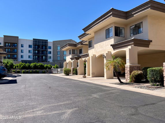 Front view of a multi-story residential building with covered parking.