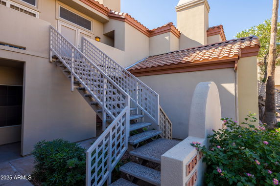 Front view of a two-story building with exterior stairs and a tiled roof.