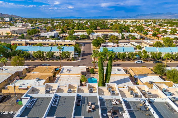 Aerial panoramic view of a suburban area with multiple residential buildings and clear sky.