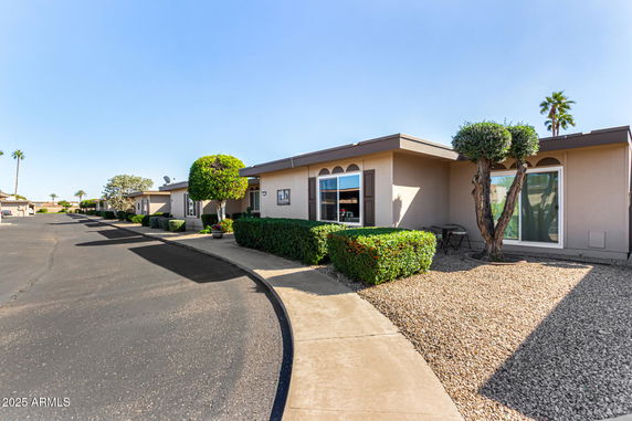 Front view of a single-story house with a flat roof and large windows.