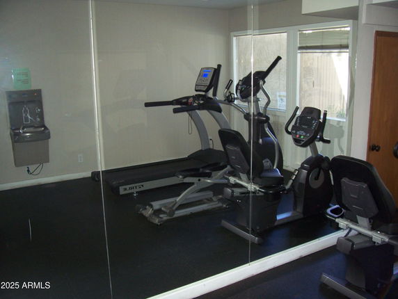 Indoor gym area with exercise equipment and a water fountain.