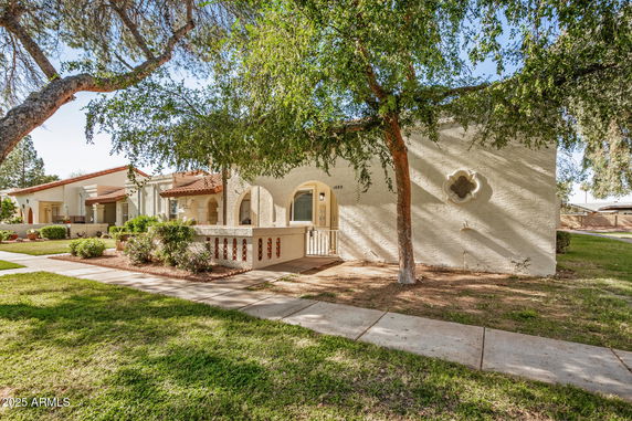 Front view of a single-story house with arches and stucco exterior.