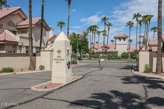 Entrance view of a residential complex with decorative pillars and tiled roofs.