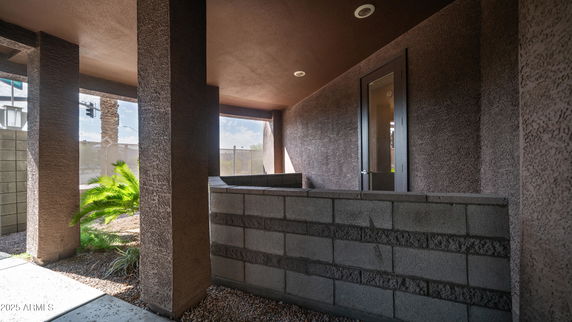 Corner view of a building with textured brown walls and glass door entrance.