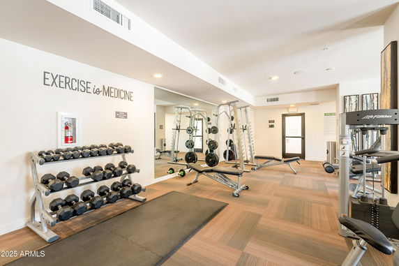 Interior view of a gym with exercise equipment and weights.
