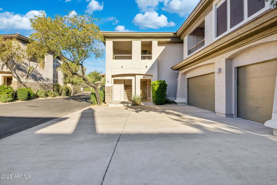 Front view of a two-story building with garages and balconies.