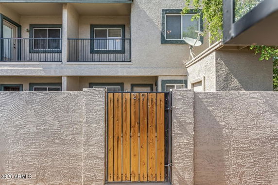 Front view of a two-story house with a wooden gate and balcony.